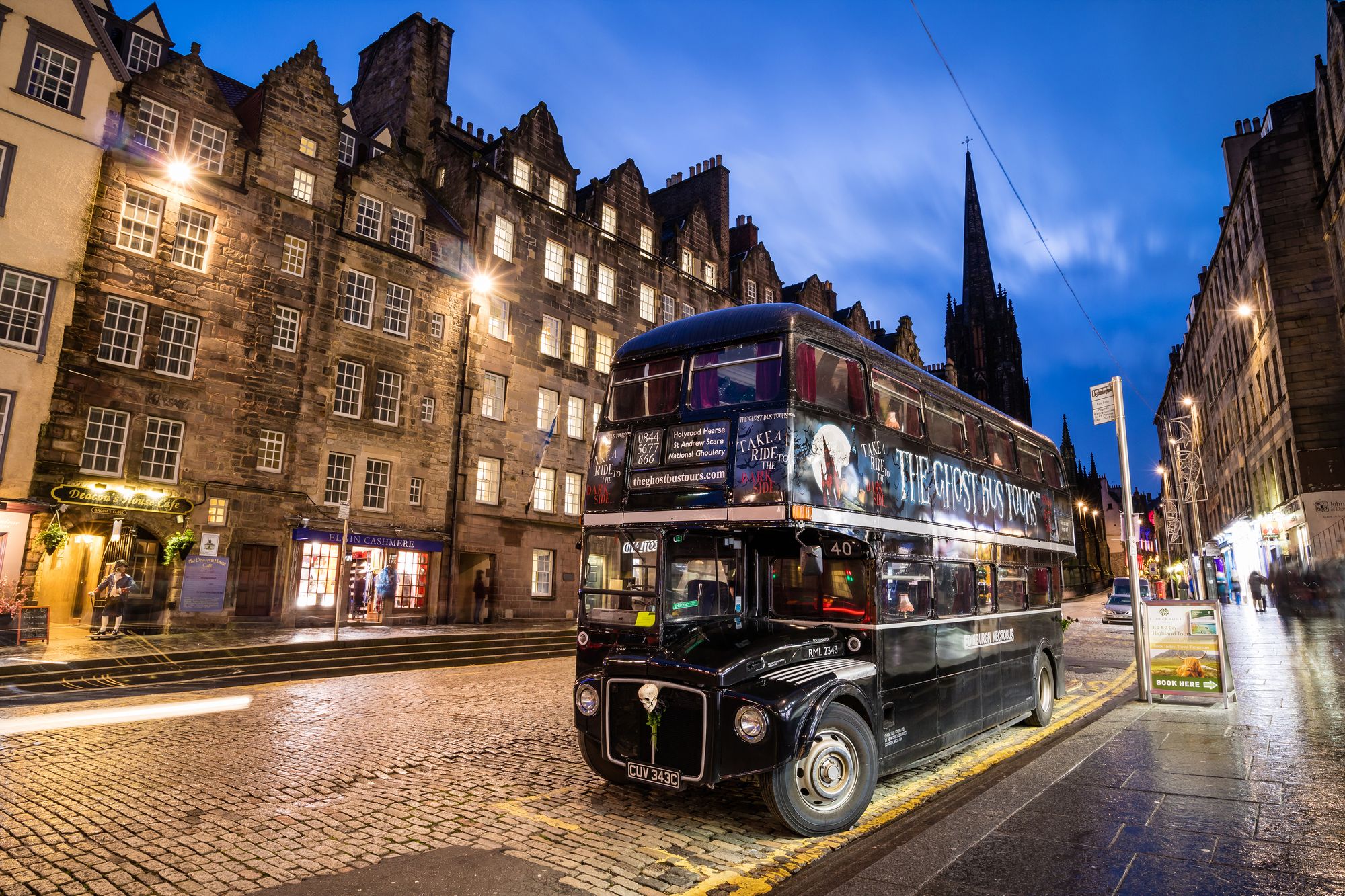 Ônibus preto funerário do Ghost Bus Tour estacionado à noite em rua histórica de Edimburgo na Escócia